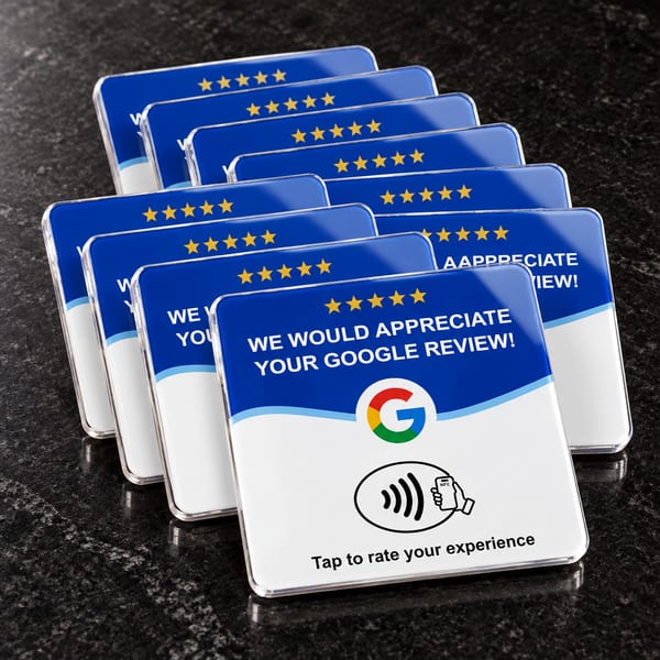 Fanned blue acrylic Google review cards on a dark countertop.